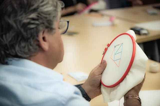 Aldo Civico doing needlepoint with the Social Lab Castilla participants