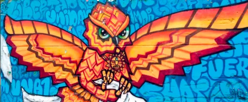 Street art graffiti in Medellin of an orange phoenix on a blue background