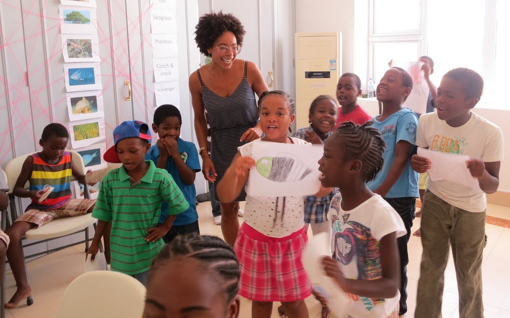 Grappling With Ocean Conservation and Social Justice Ayana Johnson with a group of young elementary school aged children teaching about marine biology and social justice.